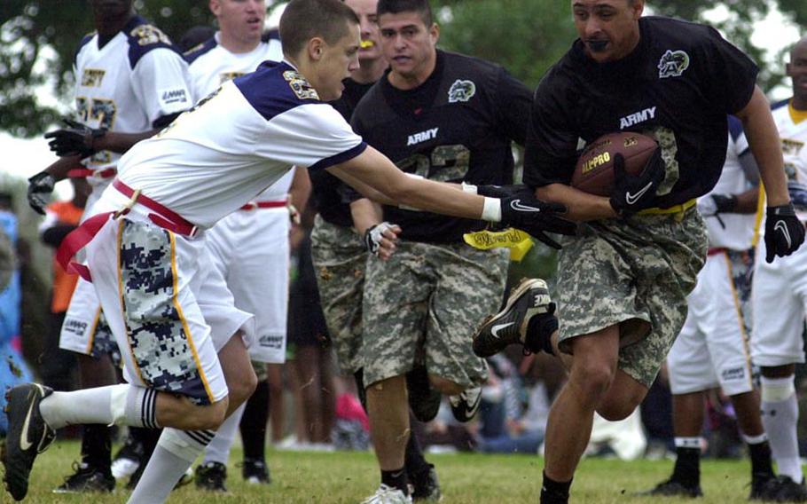 Army kick returner Antwyne Papion, right, tries to elude the tackle of Navy kicker Cody Wells during Saturday's 22nd Okinawa Army-Navy flag football game at Torii Field, Okinawa. Army rallied from a 21-12 deficit to beat Navy 25-21.
