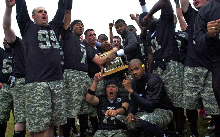 Army players and coaches celebrate with the Commander's Trophy after Saturday's 22nd Okinawa Army-Navy flag football game at Torii Field, Okinawa. Army rallied from a 21-12 deficit to beat Navy 25-21.