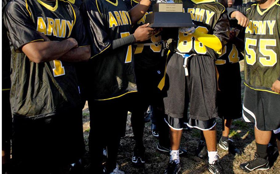 Army soldiers surround the championship trophy after Saturday's 10th Japan Army-Navy flag football game at Zama American High School, Japan. Army won 19-7, its second straight win, tying the series 5-5.