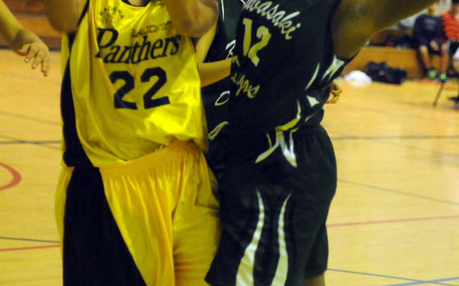 Maria Vaughan of the Kadena Panthers is fouled going to the basket by Sydney Johnson of the Kubasaki Dragons during an Okinawa Activities Council girls basketball  game earlier this month at, Kadena High School. 