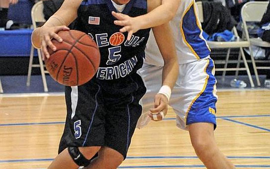 Seoul American senior Liz Gleaves dribbles past Liz Hardeman of Faith Academy during the championship game in the Far East High School Girls Division I Basketball Tournament in Guam. Seoul American beat Faith Academy for the second straight year 47-39. It was an unprecedented fourth straight D-I tournament title for Seoul American and fourth straight D-I tournament MVP award for Gleaves.