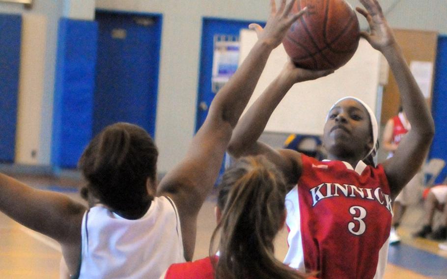 Nile C. Kinnick Red Devils freshman guard De'Asia Brown shoots over Kubasaki Dragons guard Sydney Johnson during Day 2 play in the 1st Yokota High School Christmas Classic girls basketball tournament in Japan. Kinnick won 46-29 and finished third and is off to a 10-4 start this season.