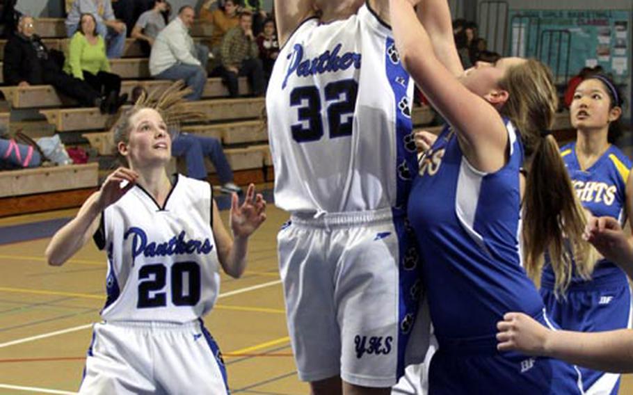 Sydney Glover of Yokota skies for a rebound between two Christian Academy Japan defenders as teammate Katelyn Sult watches during Friday's Kanto Plain Association of Secondary Schools girls basketball game at Yokota High School, Japan. The host Panthers won 64-42.