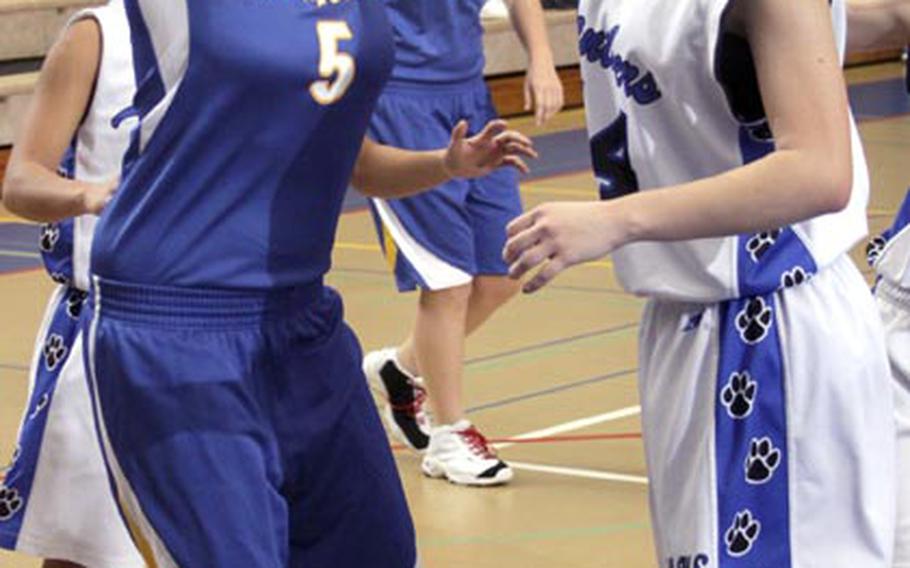 Kendra Peterson of Christian Academy Japan has her shot deflected by Kathryn White of Yokota during Friday's Kanto Plain Association of Secondary Schools girls basketball game at  Yokota High School, Japan. The host Panthers won 64-42.