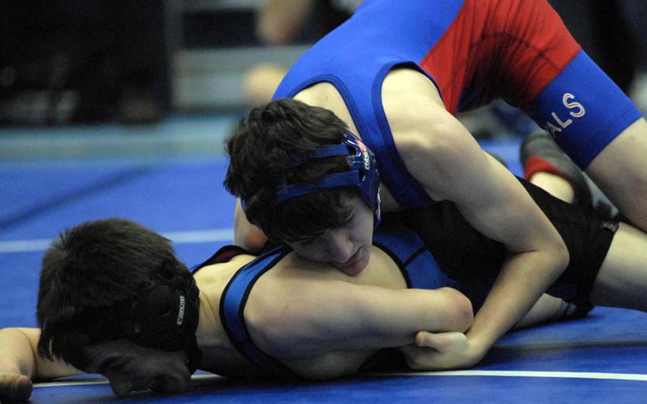 Ramstein junior Ryan Goins gets on top of Black Forest Academy junior Henry Paige during the semi-finals of the 113-pound weight category at Ramstein High School.  The Royals hosted six other DODDS-Europe teams during a Saturday afternoon tournament.