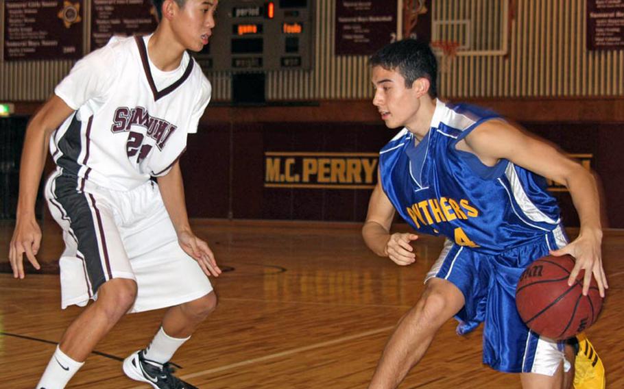 Warren Manegan of the Yokota Panthers dribbles against Sam Cadavos of the Matthew C. Perry Samurai during Friday's DODDS Japan boys basketball game at Matthew C. Perry High School, Japan. The Panthers won 51-24.