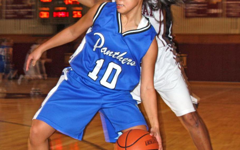 Erika Ettl of the Yokota Panthers dribbles in front of Rebekah Harwell of the Matthew C. Perry Samurai during Friday's DODDS Japan girls basketball game at Matthew C. Perry High School, Japan. The Panthers won 60-53.