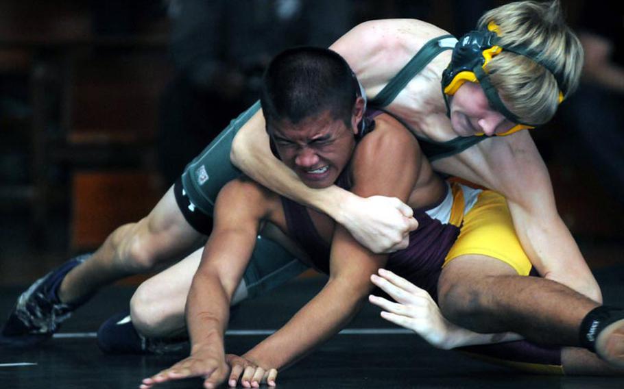 135-pounder Alejo Santos of Father Duenas Memorial grimaces as Kubasaki's Austin Cyr gains the upper hand during Saturday''s title bout in the 5th "Rumble on the Rock" Wrestling Tournament at Camp Foster, Okinawa. Cyr, named the tournament's Outstanding Wrestler, pinned Santos in 1 minute, 24 seconds for the gold. Kadena edged Kubasaki 96-95 for the team title.