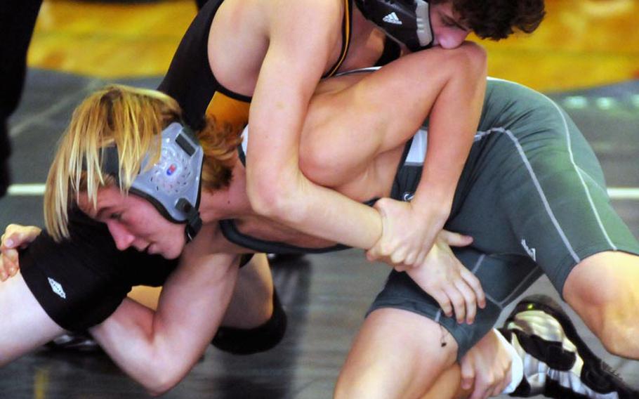 Reigning Far East tournament weight-class champion Thomas Cioppa of Kadena, top, loses his headgear as he grapples with Tristan Wells of Kubasaki during Saturday's 122-pound gold-medal bout in the 5th "Rumble on the Rock" Wrestling Tournament at Camp Foster, Okinawa. Scioppa won a three-period decision in the all-sophomore battle and Kadena edged Kubasaki 96-95 for the team title.