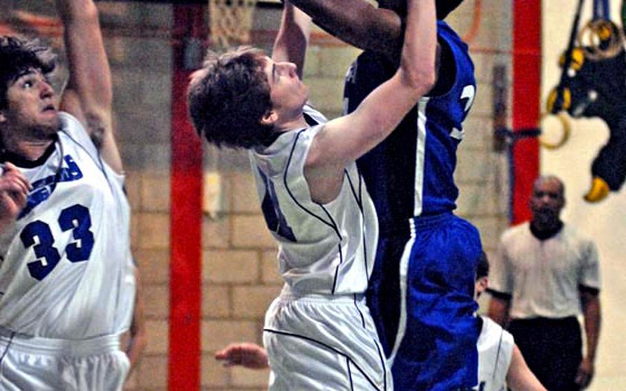 
Rota's Tre'von Owens soars above two Brussels defenders, Petar Vlahovic, left, and Daniel Helbling during a DODDS-Europe Division III contest at RAF Alconbury, England, on Saturday.