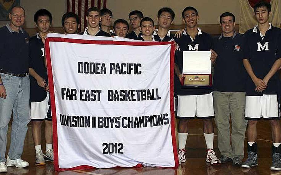 Coach Dan Robinson, left, and his Morrison Academy Mustangs celebrate their fourth straight Far East High School Boys Division II Basketball Tournament title and the sixth in school history. Morrison rallied from five points down at halftime to beat St. Paul Christian of Guam for the second straight year 47-39.