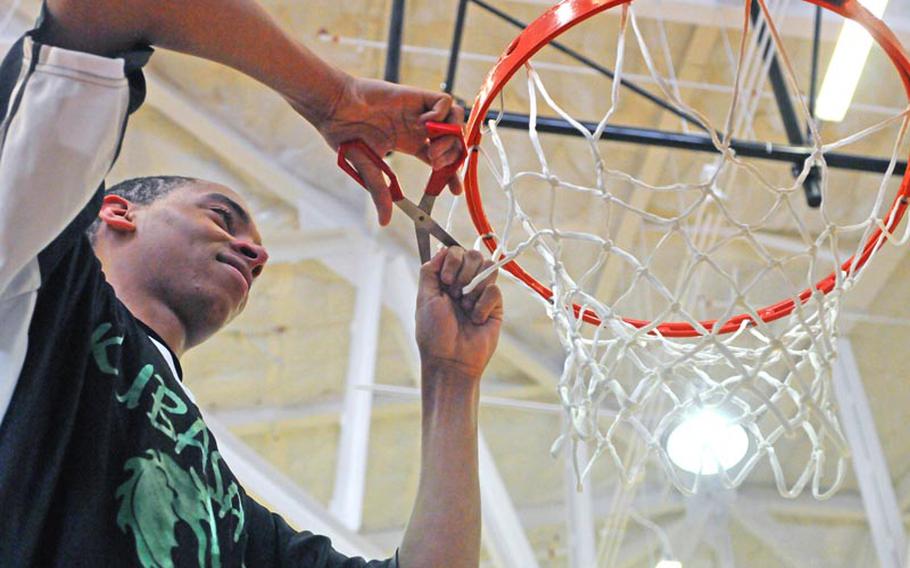 Kubasaki Dragons senior B.J. Simmons cuts down the net cords after the championship game of the 63rd Far East High School Boys Division I Basketball Tournament at Naval Station, Guam. Kubasaki defeated Okkodo of Guam 55-47 for its second straight title, its third in six years under coach Jon Fick and its Pacific-record 11th.