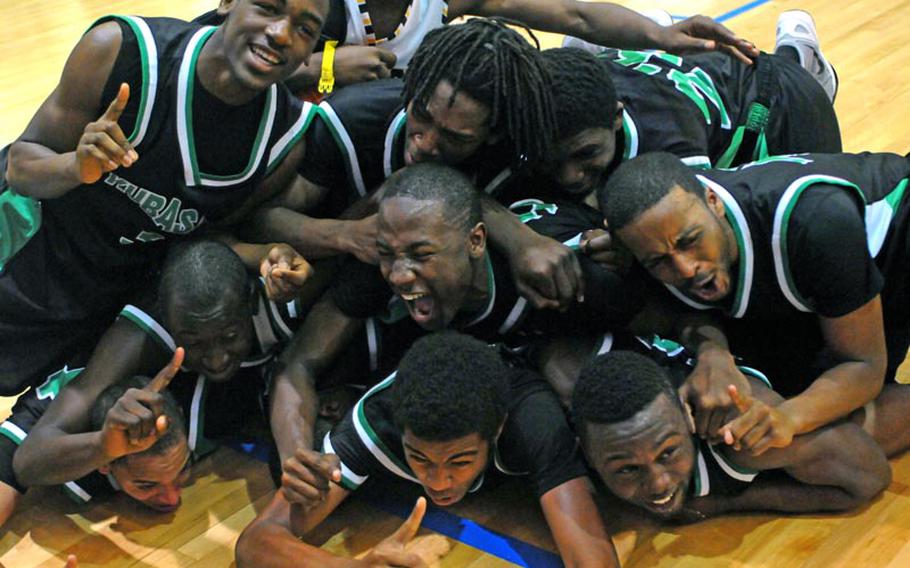 Kubasaki Dragons players celebrate dogpile style after the championship game of the 63rd Far East High School Boys Division I Basketball Tournament at Naval Station, Guam. Kubasaki defeated Okkodo of Guam 55-47 for its second straight title, its third in six years under coach Jon Fick and its Pacific-record 11th.