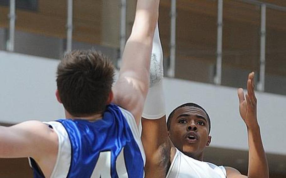 Rota's Tre'von Owens shoots over Braden Brower of Brussels at the 2012 DODDS-Europe basketball championships. Owens has been selected as the Stars and Stripes boys basketball player of the year for the second consecutive year.