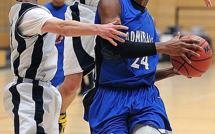 Rota's Tre'von Owens gets past Zach Ford, left, and Josh Case of Lajes for a basket in a semifinal game at the DODDS-Europe basketball championships. Owens has been selected as the Stars and Stripes boys basketball player of the year for the second consecutive year.