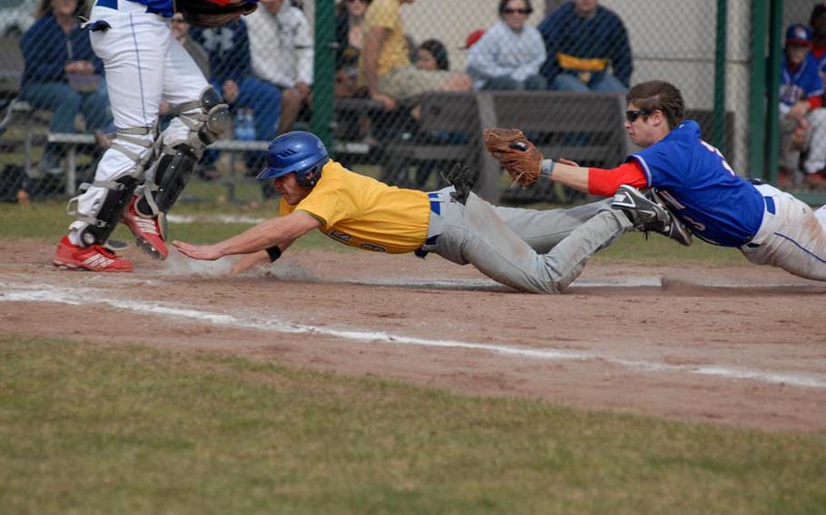 Wiesbaden senior KC Kerker tries to slide into home plate while avoiding a tag from Ramstein sophomore Matt Sharpy Saturday during opening day of baseball for DODDS-Europe. Kerker was ruled out on the play and Ramstein went on to sweep the doubleheader against the Warriors.