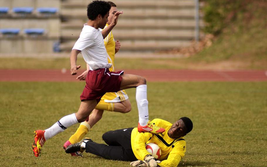 Playing goalie for the first time, Baumholder's Desante Brown makes an athletic save against SHAPE's Kristen Harsanji with defensive help from Devon Farmer in Saturday's game in Baumholder, Germany. SHAPE won the game 8-0.