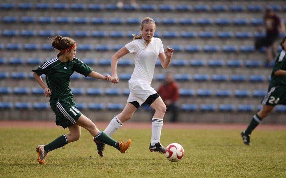 SHAPE's Karoline Soerensen takes a shot with Baumholder's Jordan Wilson playing defense during Saturday's game in Baumholder, Germany. SHAPE won the game 8-1.