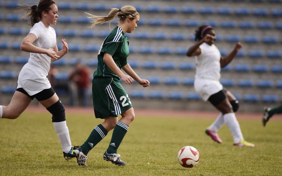 SHAPE's Miriam Sivertsen dribbles the ball ahead of Baumholder's Kayllan Torres during Saturday's game in Baumholder, Germany. SHAPE won the game 8-1.