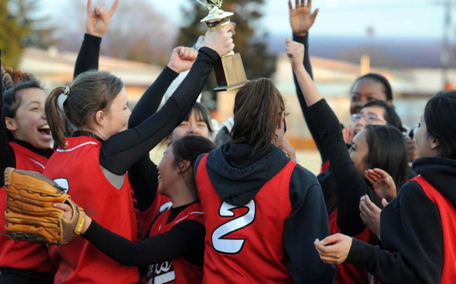 Nile C. Kinnick softball players celebrate with the trophy after Saturday's championship game in the DODDS Japan girls softball tournament at Yokota Air Base. The Red Devils edged the E.J. King Cobras 9-8.