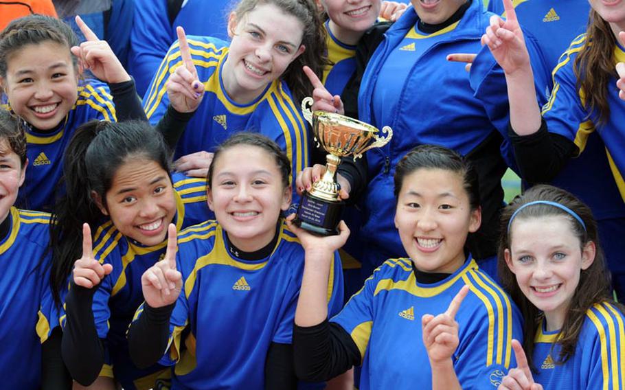 Yokota Panthers girls soccerl players celebrate with the trophy after their last match Saturday in the DODDS Japan girls soccer tournament at Yokota Air Base. The Panthers went unbeaten at 5-0.
