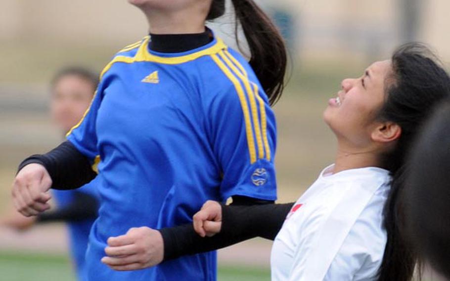 Yokota sweeper Caitlin Older takes a header in front of E.J. King's Maria Meneses during Saturday's match in the DODDS Japan girls soccer tournament at Yokota Air Base. The Panthers blanked the Cobras 5-0 en route to a 5-0 record.