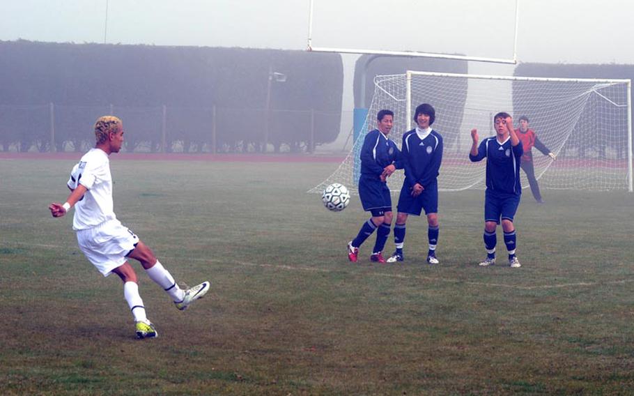 Alconbury's Tyler Grissett sends a free kick towards the goal during a match Saturday against the Bitburg Barons. Fog blanketed the field for the first half of the boys' game. The Dragons won the match 6-1.