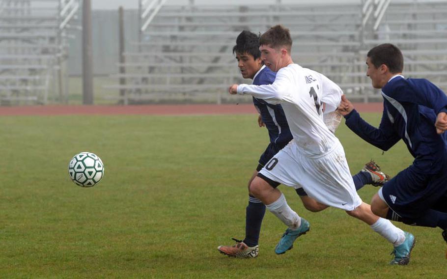 Alconbury's Ryan Mantell squeezes through Bitburg defenders Dane Robbins, right, and Damian Sotelo during a game Saturday at RAF Alconbury. Mantell had three goals in the first half of the match and the Dragons won 6-1.