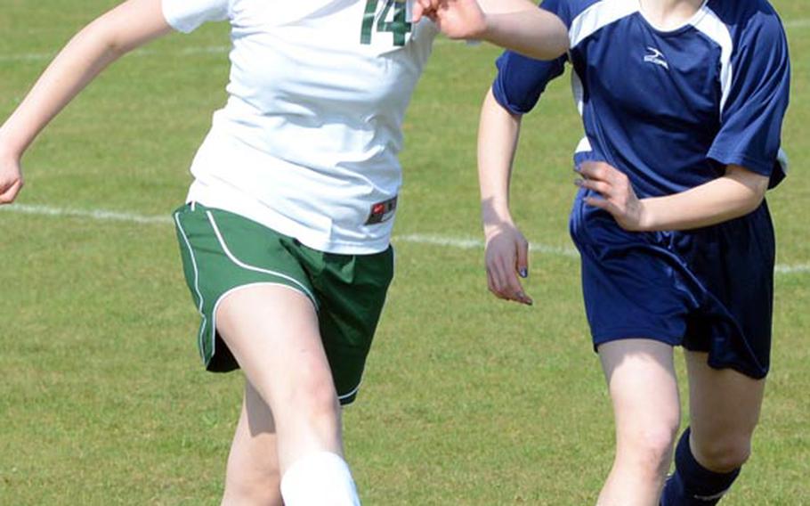 Alconbury's Ronnie Jacquard boots the ball while Bitburg's Anne-Marie Clark defends during a Saturday game at RAF Alconbury, England. Bitburg won the match 2-0.