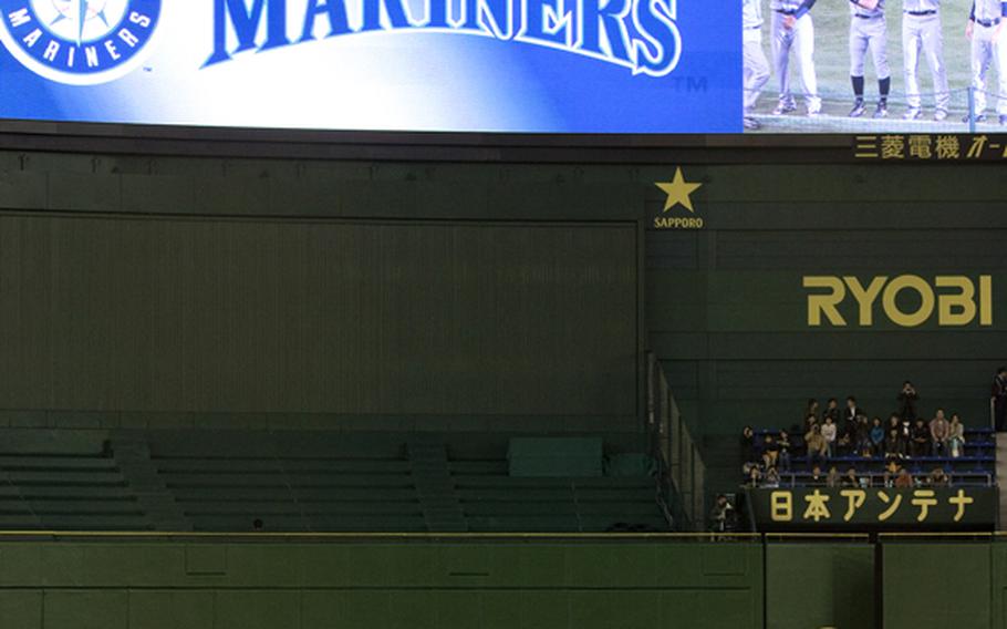 Servicemembers from all branches of the military parade the American flag during the opening ceremony of the American League season opening MLB baseball game between the Seattle Mariners and the Oakland Athletics in Tokyo.