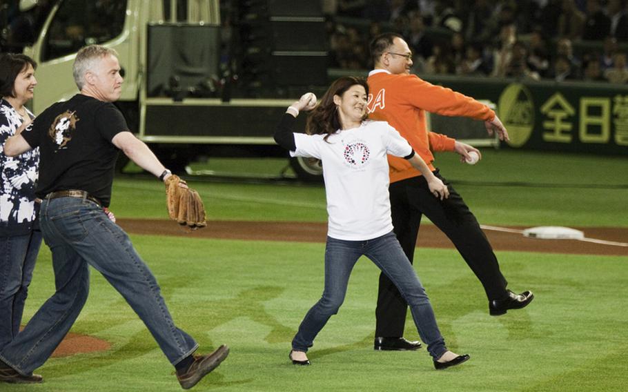 Andy Anderson, left, and his wife Jean, far left, parents of Taylor Anderson -- who was killed by the March 11, 2011 tsunami and earthquake in Ishinomaki --throw the ceremonial first pitch with tsunami survivor Shinji Takai, right and Naho Hozumi, middle, Hands-On Tokyo's disaster relief program manager, before the American League season opening MLB game between the Seattle Mariners and the Oakland Athletics in Tokyo.