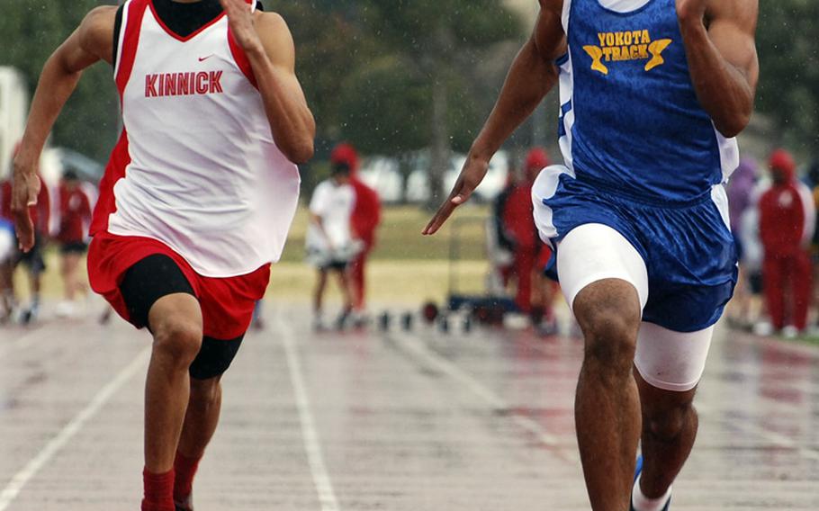 Yokota's Preston Brooks, right, outsprints Justin Smith of Nile C. Kinnick to the tape to win the boys 100-meter dash in Saturday's DODDS Japan-Kanto Plain Association of Secondary Schools track and field meet at Yokota Air Base.