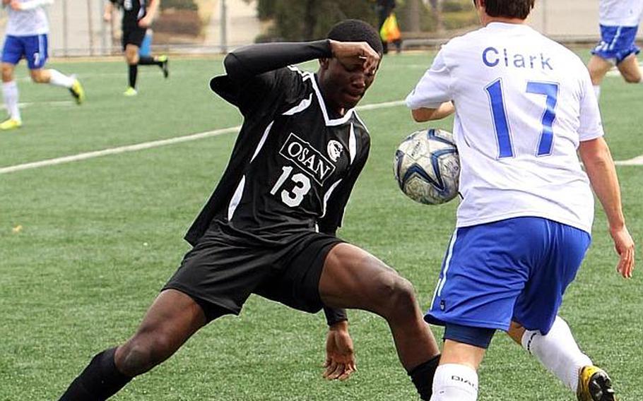 Degraft Agyei of the Osan American Cougars and Seoul American's Andrew Clark battle for the ball during Saturday's Korean-American Interscholastic Activities Conference Boys Division I soccer match at Yongsan Garrison, South Korea. The Falcons won 3-1.