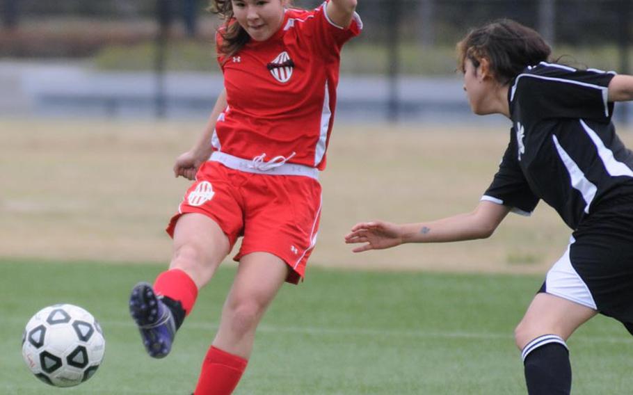 Nile C. Kinnick striker Kaile Johnson boots the ball past a Matthew C. Perry defender during Friday's DODDS Japan soccer match at Kuga Field, Japan. The teams tied 0-0 in the first of two meetings; Kinnick won the next one 1-0 on a goal by Elisha Dareing.