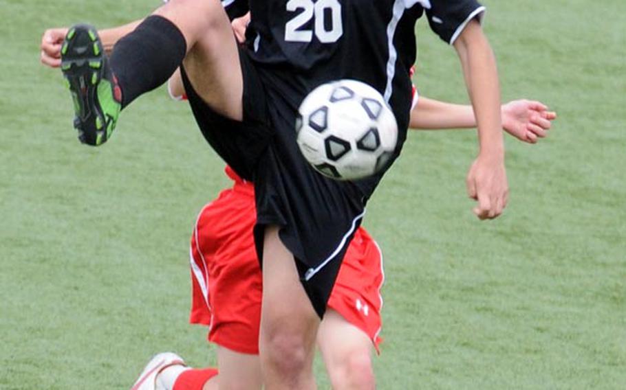 E.J. King's Adam Sobieck tries to settle the ball against a Nile C. Kinnick defender during Friday's DODDS Japan soccer match at Kuga Field, Japan. Kinnick won 2-0.