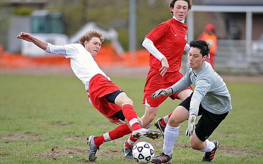 Kaiserslautern's Cody Tremaine, left, tries to get the ball past ISB goalie Matthijs De Gooijer as Jack Willows follows the action at center. Saturday's game in Kaiserslautern ended 1-1.