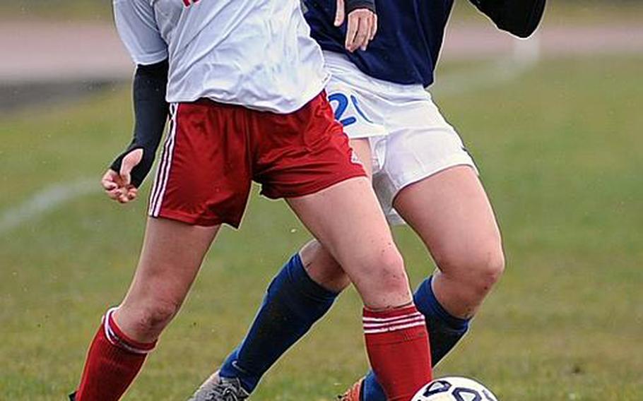 Kaiserslautern's Emily Crawford, left, and Elena Venturoni of International School of Brussels fight for the ball in their match in Kaiserslautern, Saturday. The home Raiders beat the visiting Raiders 3-2, in a game played mostly in a driving rain.