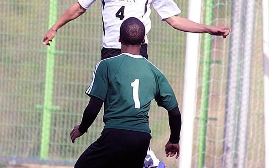 Matt Murphy of Osan American heads the ball in front of Darius Wyche of Daegu during Friday's opening match in the Korean-American Interscholastic Activities Conference Boys Division I Soccer Tournament at Gyeonggi Suwon International School,  South Korea. Osan won 1-0.