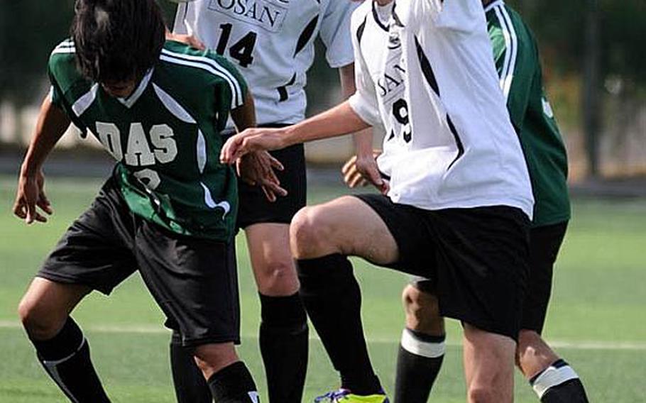 Carlo Bonifacio of Daegu heads the ball in front of Osan American's Nick Sutton, right, and Tyrone Boylan during Friday's opening match in the Korean-American Interscholastic Activities Conference Boys Division I Soccer Tournament at Gyeonggi Suwon International School, South Korea. Osan won 1-0.