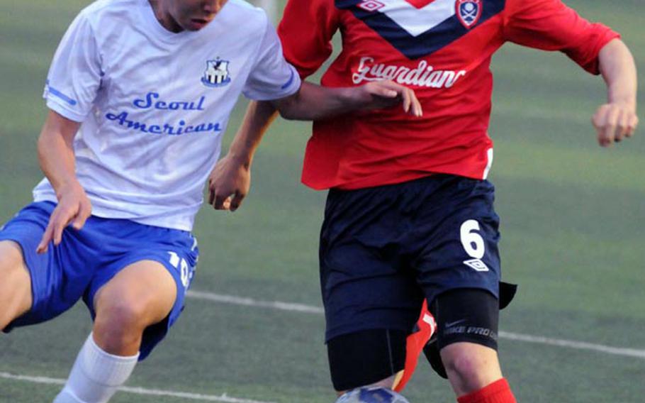 Seoul American's Ho Kyung Shin, left, and Yongsan International-Seoul's Sanghyun Park battle for the ball during Saturday's championship match in the Korean-American Interscholastic Activities Conference Boys Division I Soccer Tournament at Suweon, South Korea. The Guardians edged the Falcons 2-1.