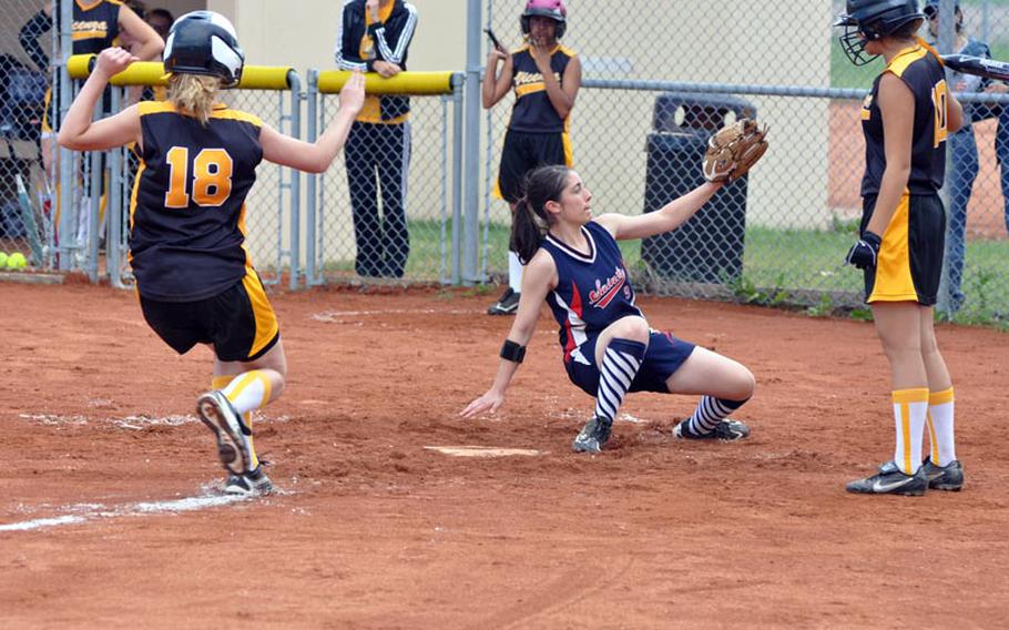 Aviano pitcher Dani Lippert awaits a throw while covering home in the second game of a doubleheader at Aviano as Vicenza's Lauren Rajotte runs in to score. Lippert slipped and was hurt on the play and had to watch the rest of the contest from the dugout.