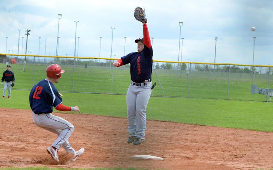Bitburg's Josiah Laser jumps to try to catch an errant throw to first base as Lakenheath's Devon Parrish tries to avoid running into him, during a Saturday matchup at RAF Feltwell, England. Lakenheath won both games of the doubleheader.