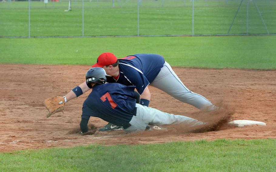 Lakenheath's Ian Hudak catches a throw from his first-base position just before Bitburg's Eli Olson slides into the base. Lakenheath won both games of their doubleheader, Saturday, at RAF Feltwell, England.