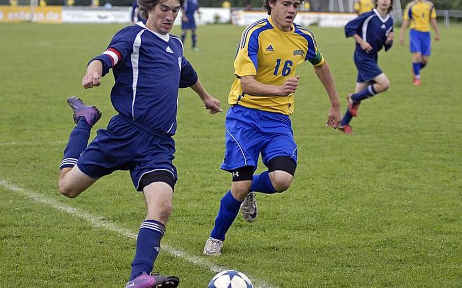 Bitburg senior and co-captain Brandon Roesch kicks the ball while Wiesbaden junior Devan Tisdale tries to catch up on Saturday during the final regular season matchup for the two teams. Wiesbaden went on to win, 7-0.