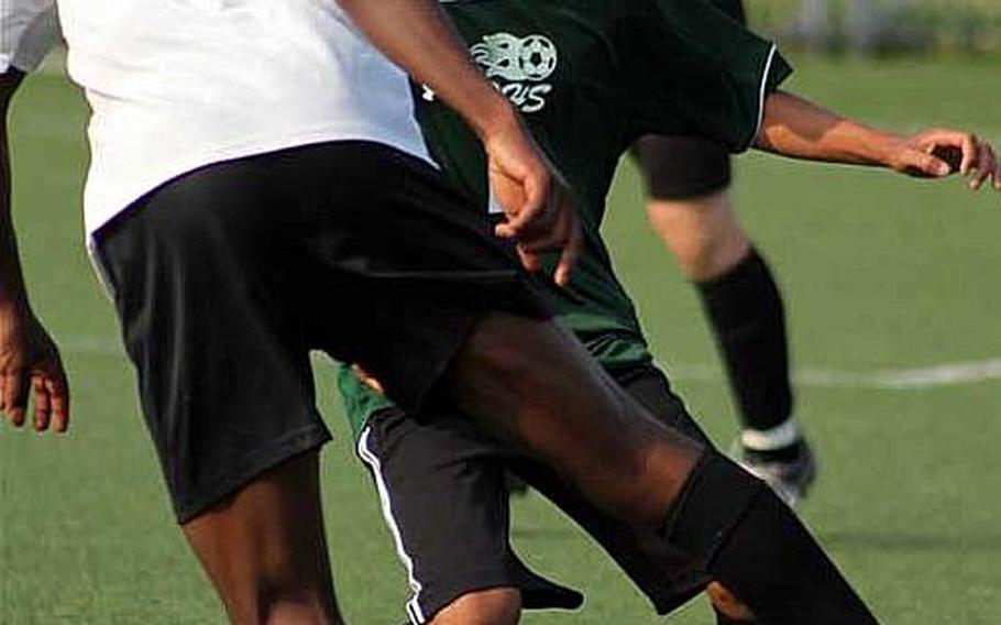 Manasseh Nartey of Osan American fields the ball in front of Carlo Bonifacio of Daegu during Wednesday's double-elimination playoff match in the Far East High School Boys Division II Soccer Tournament at Camp Humphreys, South Korea. Osan won 2-0.