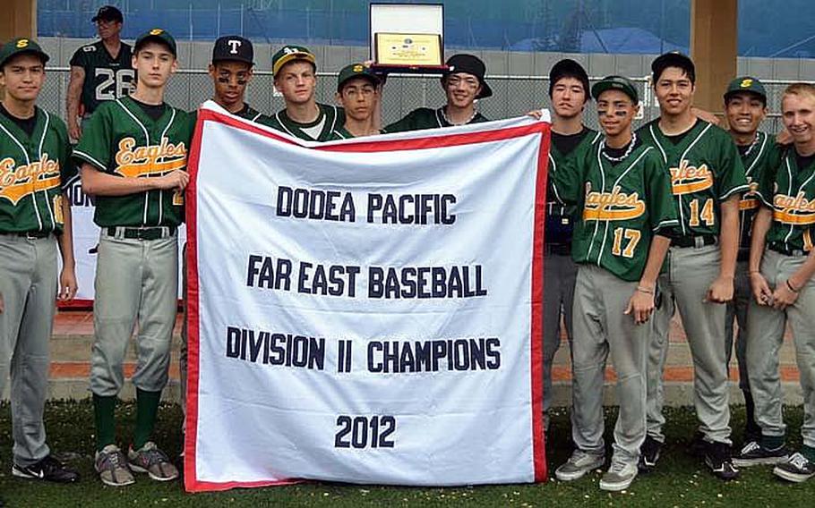 Robert D. Edgren players celebrate with the banner following Thursday's Far East High School Baseball Division II Tournament championship after a 7-0 shutout of Osan American at Camp Walker, South Korea.