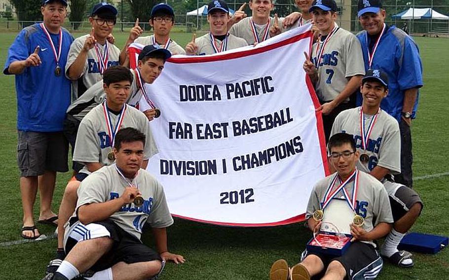 Seoul American Falcons coaches and players celebrate with the banner following Thursday's Far East High School Baseball Division I Tournament championship after an 8-7 eight-inning victory over Kadena at Camp Carroll, South Korea.