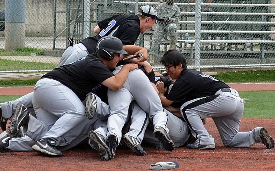 Seoul American Falcons players form a dogpile at home plate following Thursday's Far East High School Baseball Division I Tournament championship after an 8-7 eight-inning victory over Kadena at Camp Carroll, South Korea.