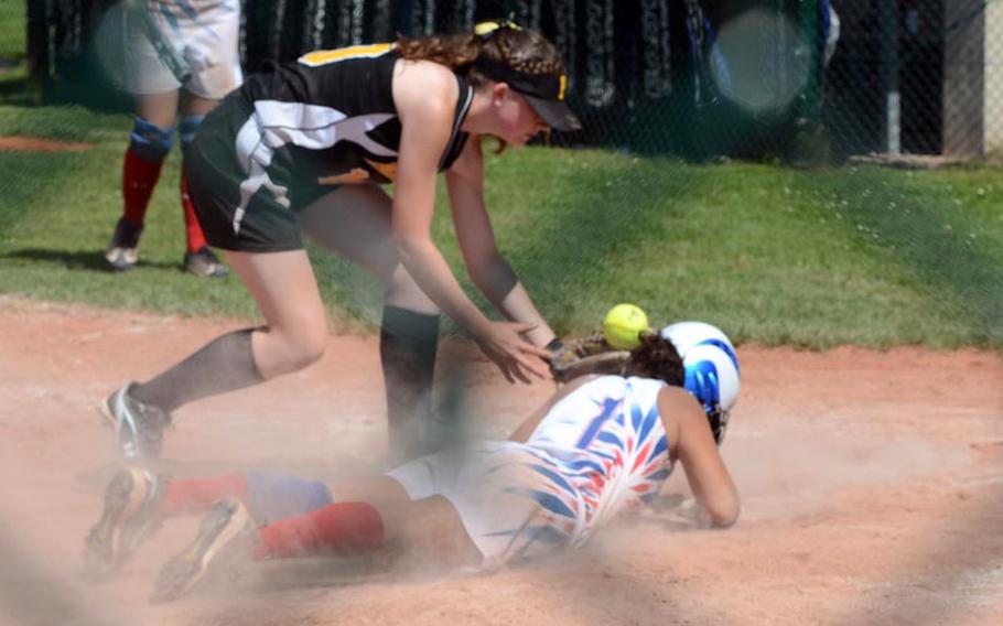 Ramstein's Savannah Brooks slides safely into home plate as Patch's Mikala Cunningham can't handle the toss from the catcher during the second day of action in the DODDS-Europe softball championship from Ramstein Air Base in Germany. Ramstein won 13-7.