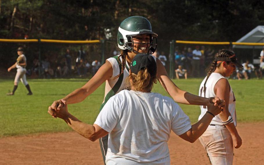 Naples sophomore Vicky Krause celebrates with softball coach Jesse Costa after a late rally in the team's championship win over AFNORTH on Saturday. Naples claimed the Division II title of the DODDS-Europe high school tournament.